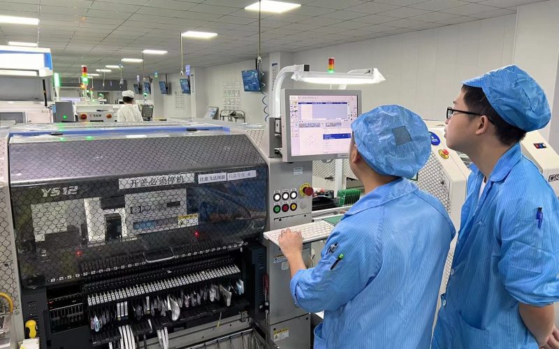 echnicians working in a clean, organized factory environment focused on PCB assembly, highlighting precision, quality control, and key steps in the electronics manufacturing process.